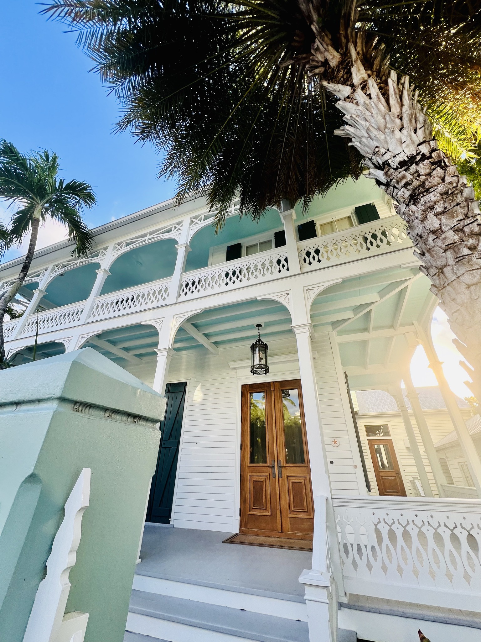 Aerial view of Key West homes with turquoise water and palm trees.